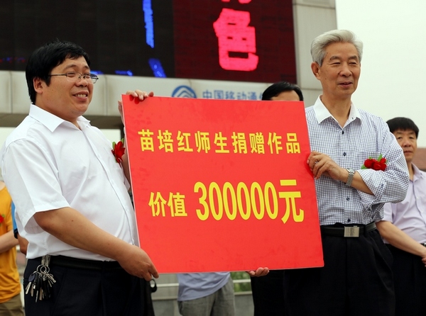 苗培红(右)为确山靖宇小学捐赠价值30万元的书法作品 子玉摄
